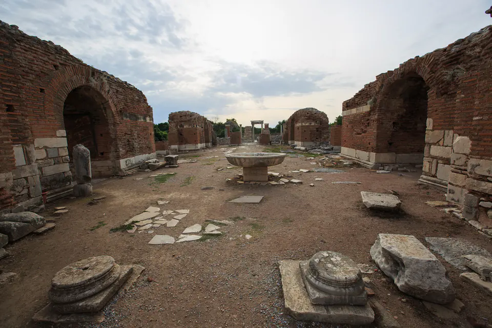 Brick arches along the long hall of the Church of Mary with a stone font in the middle