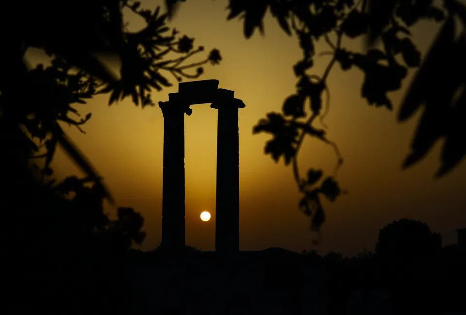 Two standing columns of the Temple of Apollo silhouetted against a golden sunset, Didyma