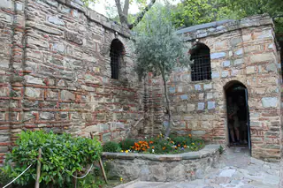 The stone House of the Virgin Mary with its garden and arched doorway
