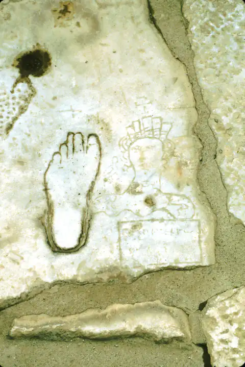 A footprint and other marks carved into a marble paving slab