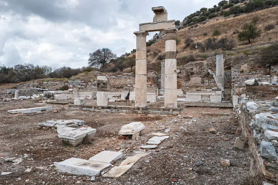 The Prytaneion columns and their foundations in the foreground under a stormy sky