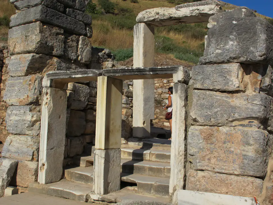 A marble doorway with steps leading into a bath building