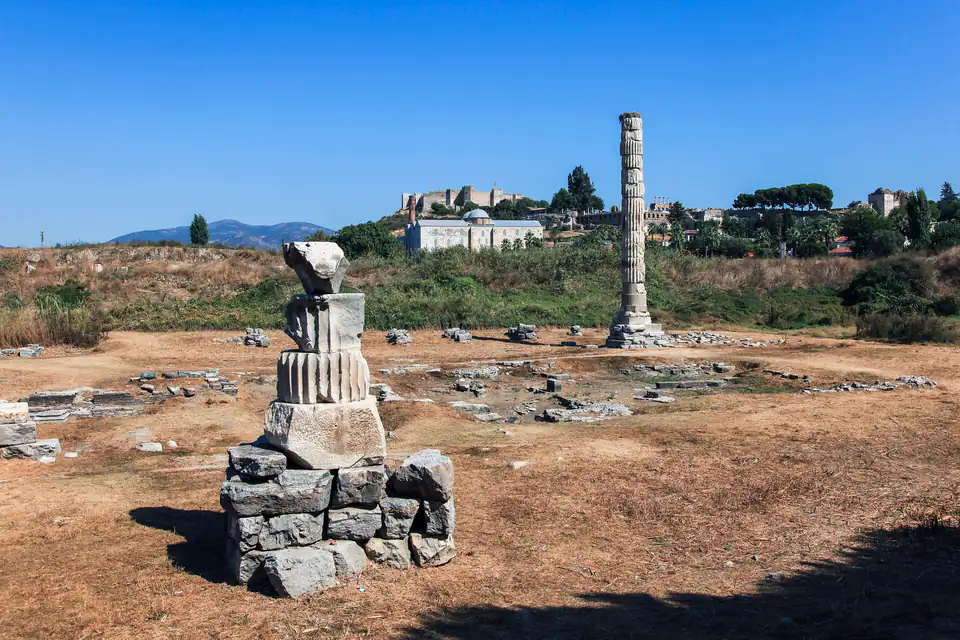 A stack of column fragments and the lone standing column on the dry Artemision site