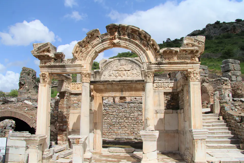 The Temple of Hadrian on Curetes Street, with its arched front against a green hillside