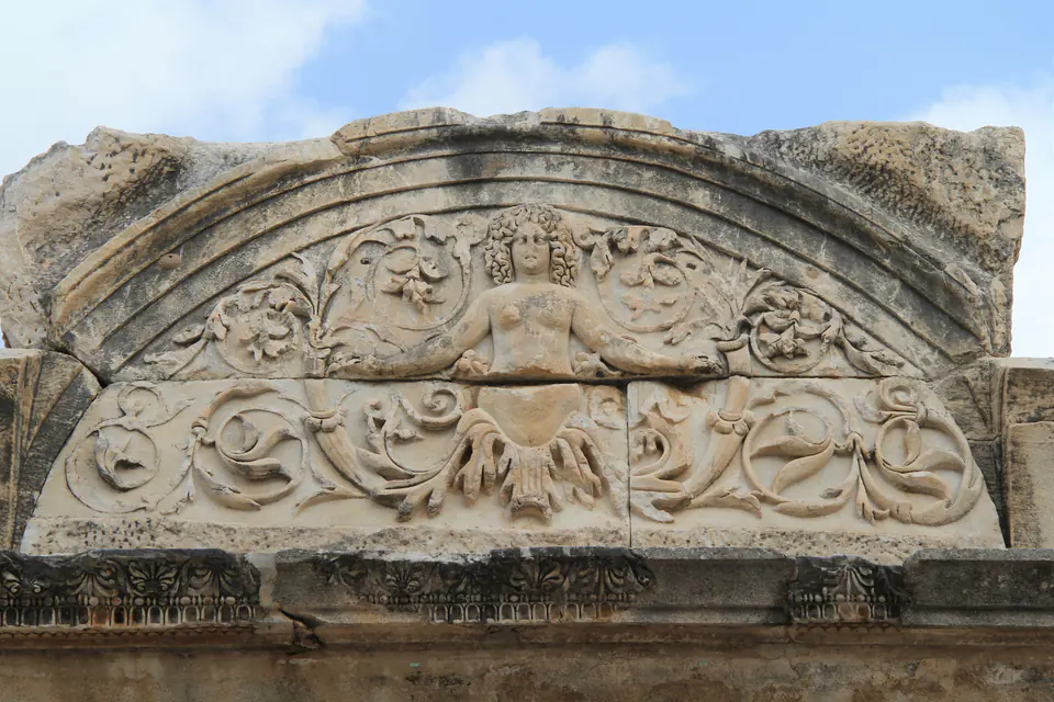 The lunette of the Temple of Hadrian with a female figure among acanthus scrolls