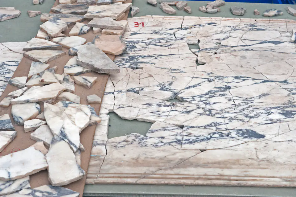 Frammenti di rivestimento marmoreo venato di blu, disposti per il rimontaggio, case a terrazzo